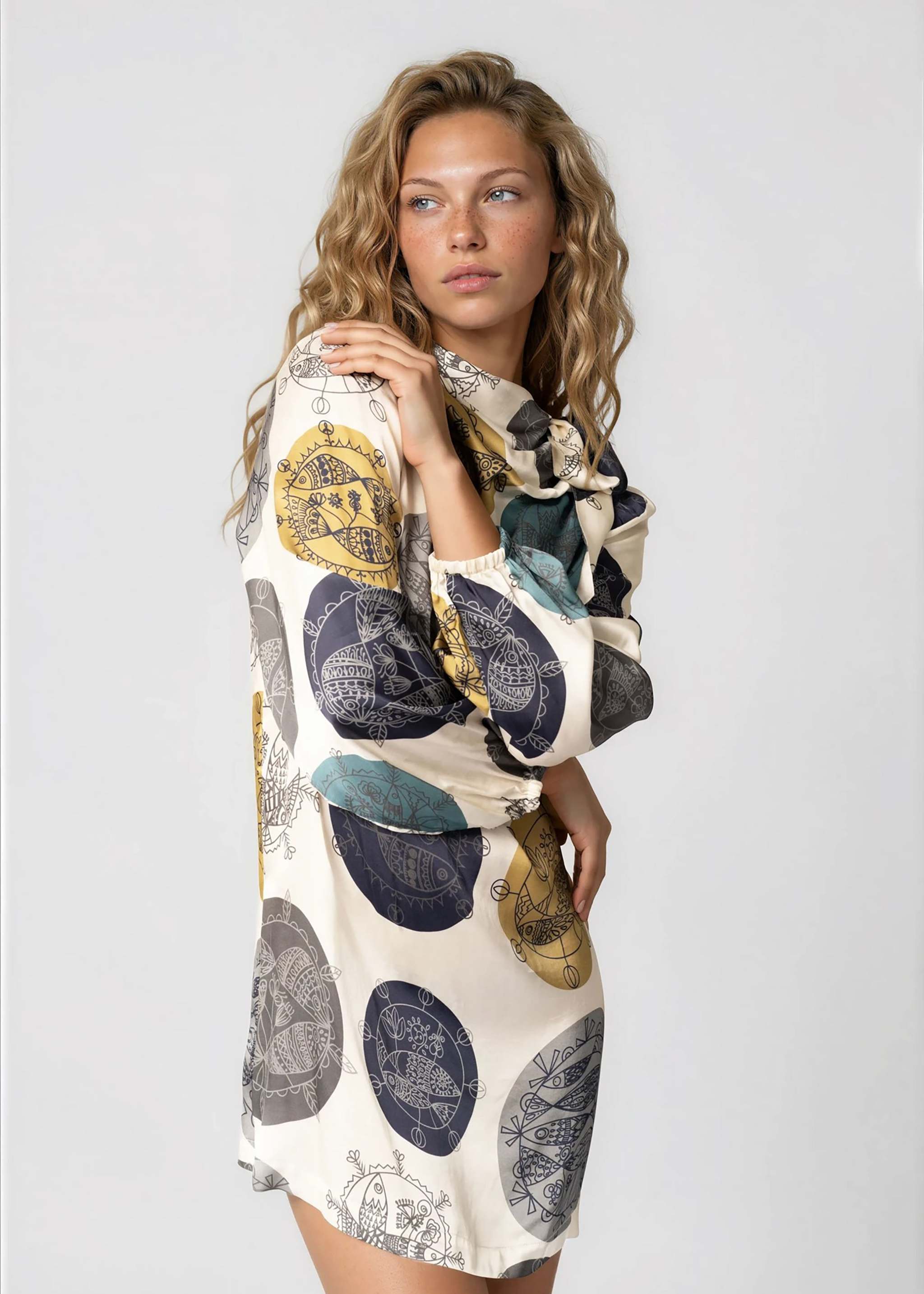 Woman wearing a daylight ocean dream high neck mini dress with bell sleeves and self-tie neck detail