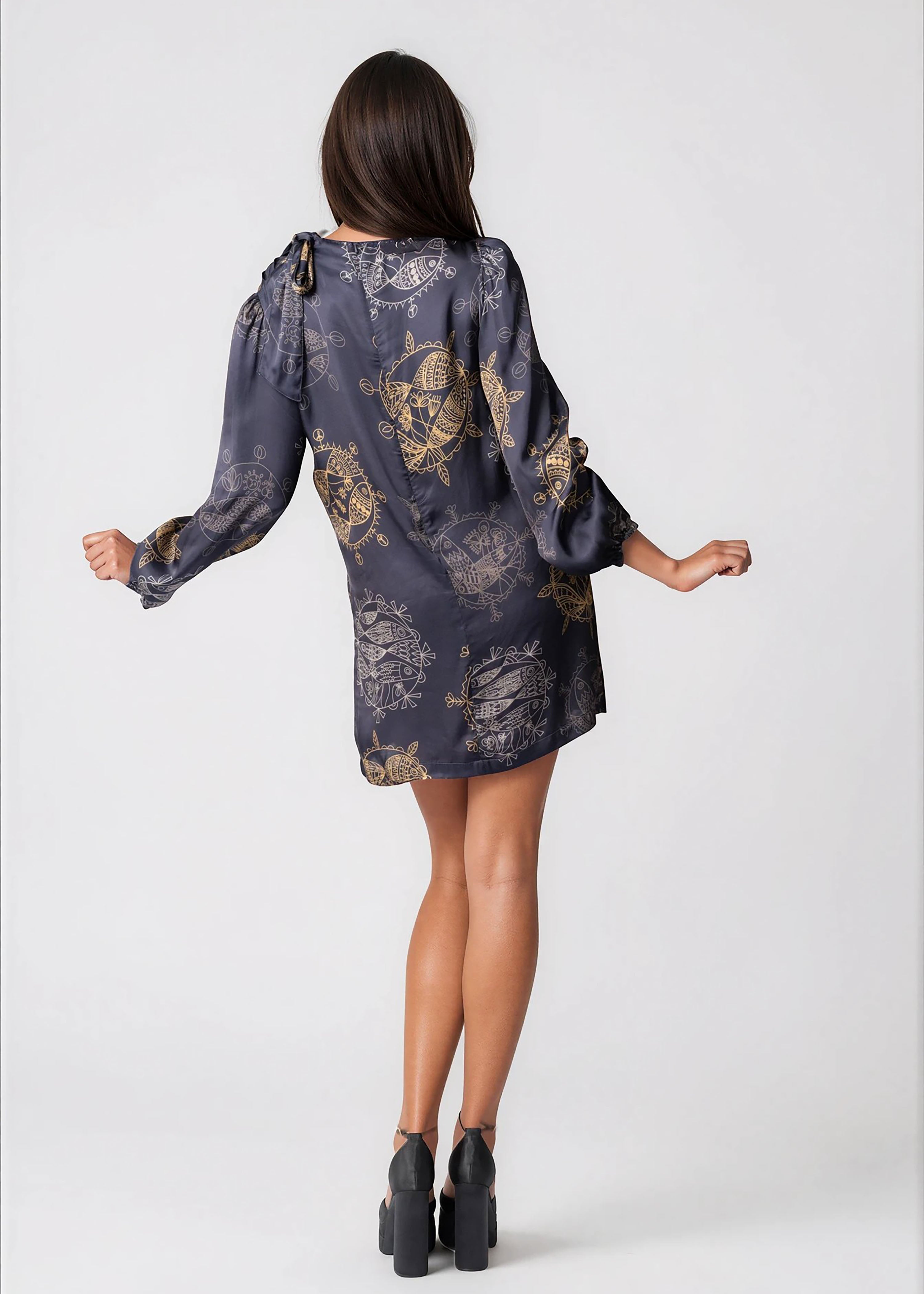 Woman wearing a twilight ocean dream high neck mini dress with long bell sleeves and neck tie detail