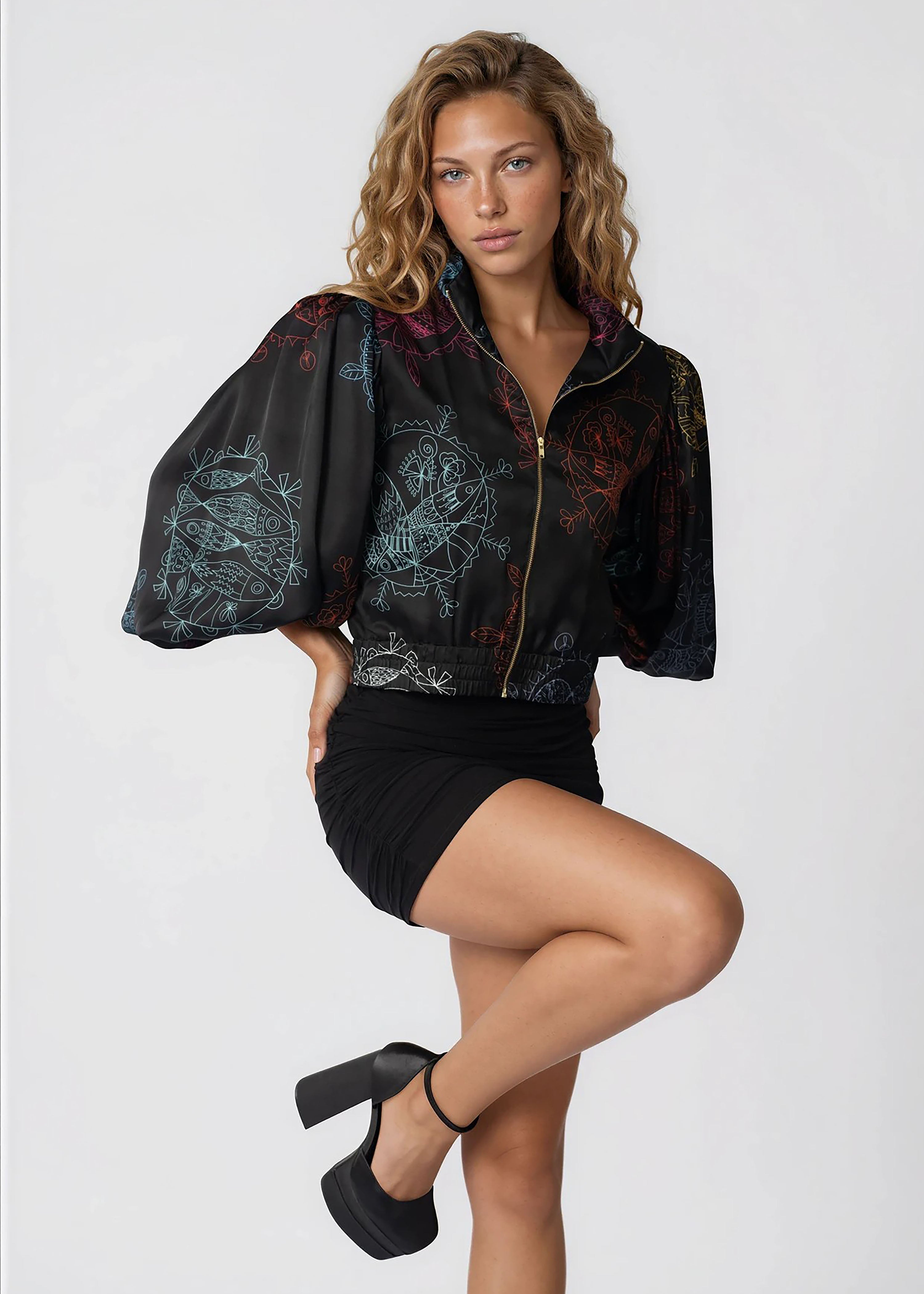 Woman wearing cropped bomber jacket with oversized gathered bell sleeves and front zipper in midnight ocean dream design