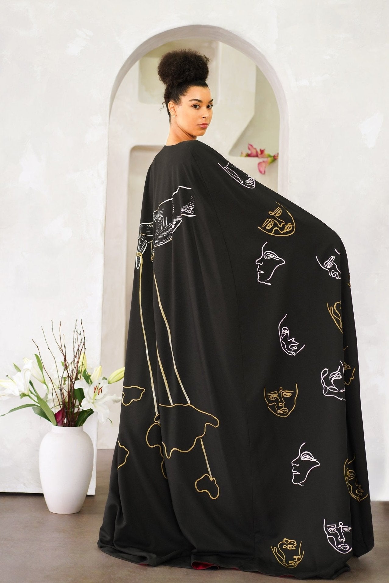 Model wearing Invisible Government Asymmetric Cape and Pants with a hand-painted world map design