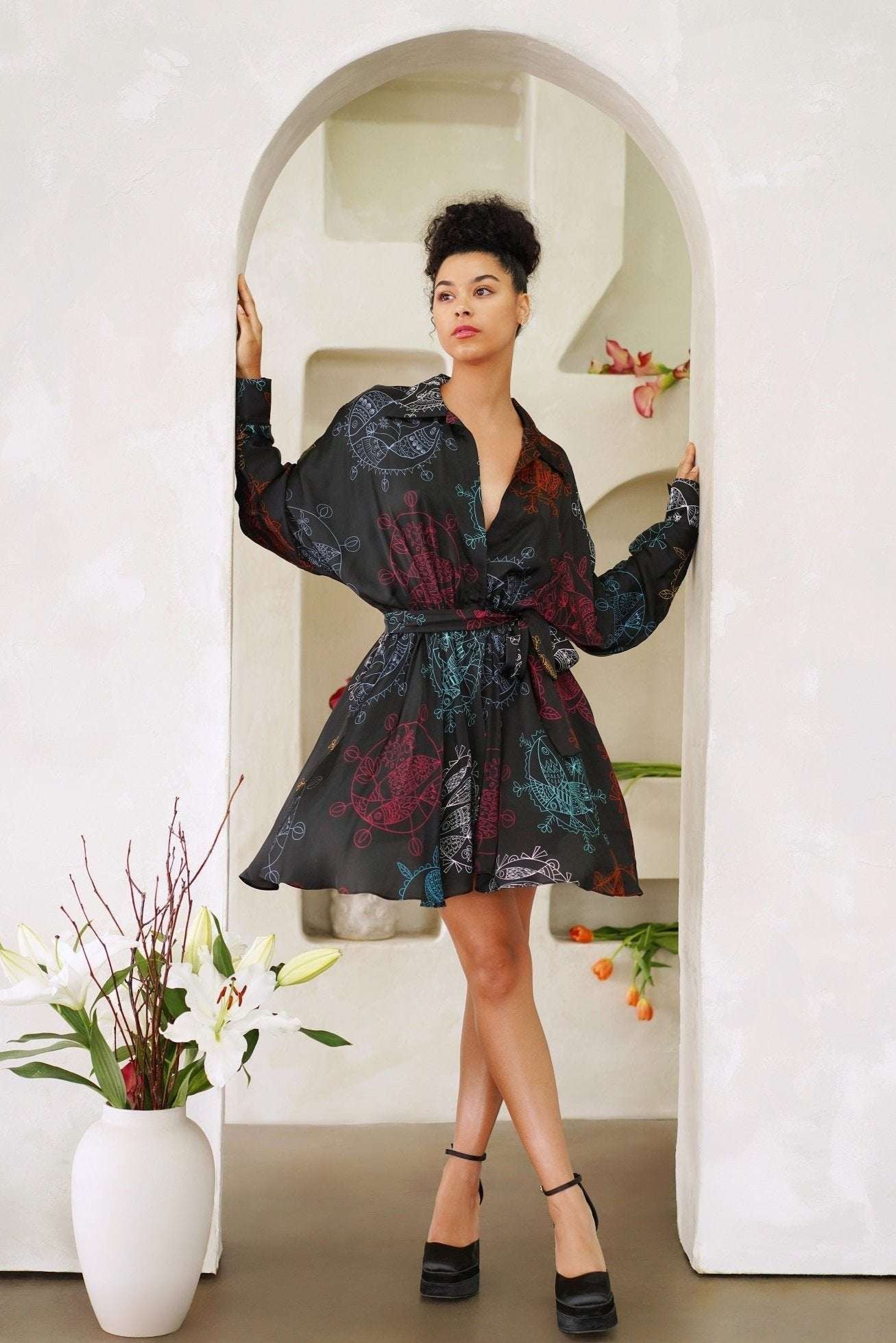 Woman wearing flared mini dress with structured collar and self-tie waist belt in midnight ocean dream pattern