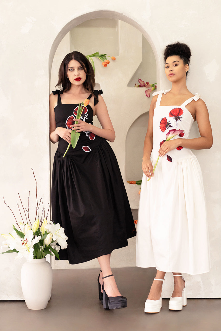 Two women in  elegant dresses: one black & other one in  white 