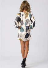 Woman wearing high neck mini dress with long bell sleeves and neck tie in lightweight fabric