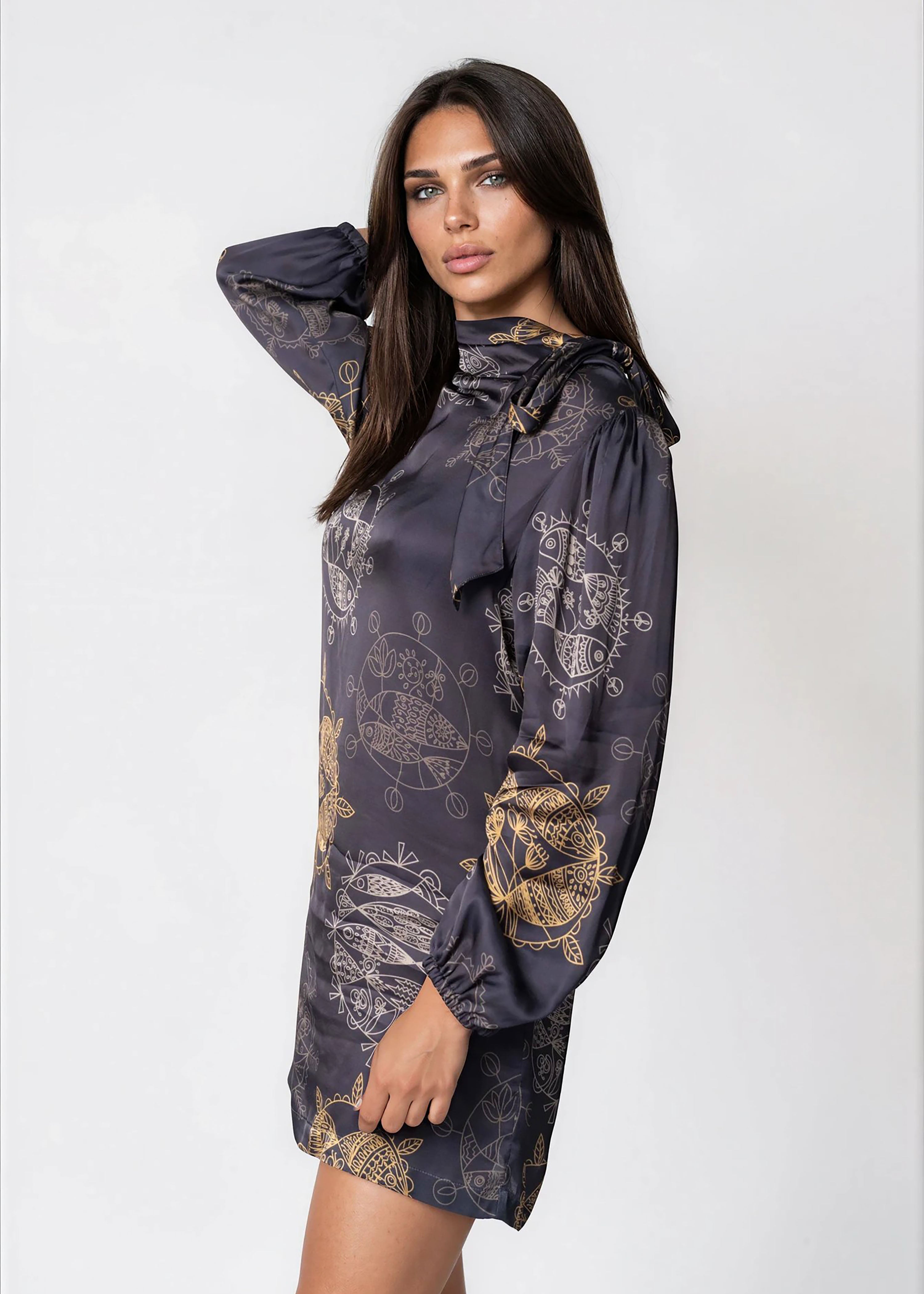 Woman wearing a Twilight Ocean Dream high neck mini dress with long bell sleeves and self-tie neck detail