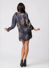 Woman wearing a twilight ocean dream high neck mini dress with long bell sleeves and neck tie detail