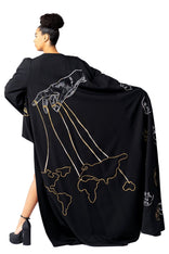 Model wearing Invisible Government Asymmetric Cape and Pants with hand-painted world map design