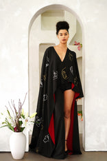 Model wearing Invisible Government asymmetrical hand-painted cape and one-leg silk wool pants with a V-neck and wide-leg design