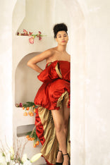 Woman wearing a red peony ruffled asymmetric gown with hand-painted birds and puff skirt