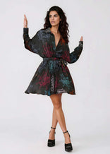 Woman wearing flared mini dress with self-tie waist belt and long sleeves in midnight ocean pattern